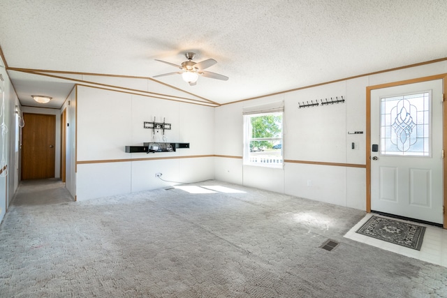 interior space with lofted ceiling, carpet, ceiling fan, and a textured ceiling