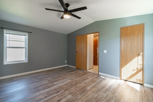 unfurnished bedroom with lofted ceiling, ceiling fan, and wood-type flooring