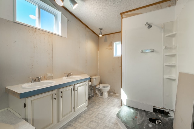 bathroom featuring toilet, crown molding, vanity, a textured ceiling, and a shower