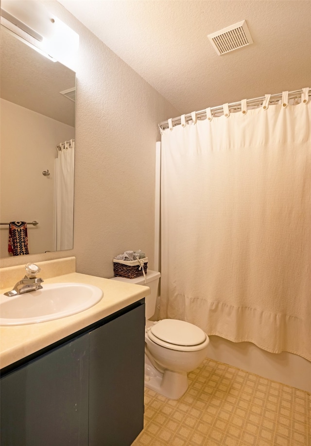 full bathroom featuring vanity, a textured ceiling, toilet, and shower / tub combo