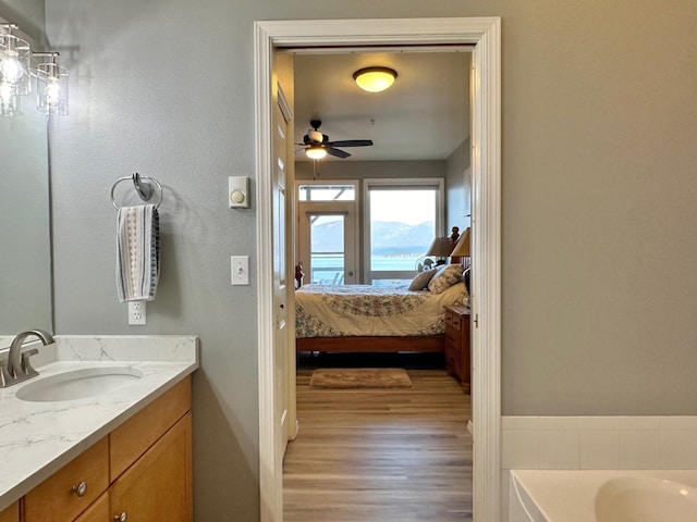 100 Rocky Point Rd Unit B-2, Polson, MT 59860 - ensuite bathroom featuring ceiling fan, vanity, a tub, wood finished floors, and ensuite bathroom
