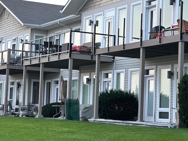 view of side of property featuring a yard and a balcony