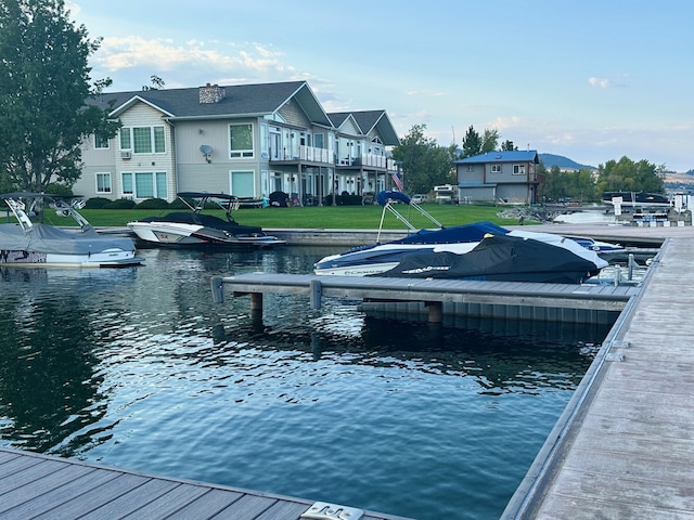 view of dock featuring a water view and a lawn