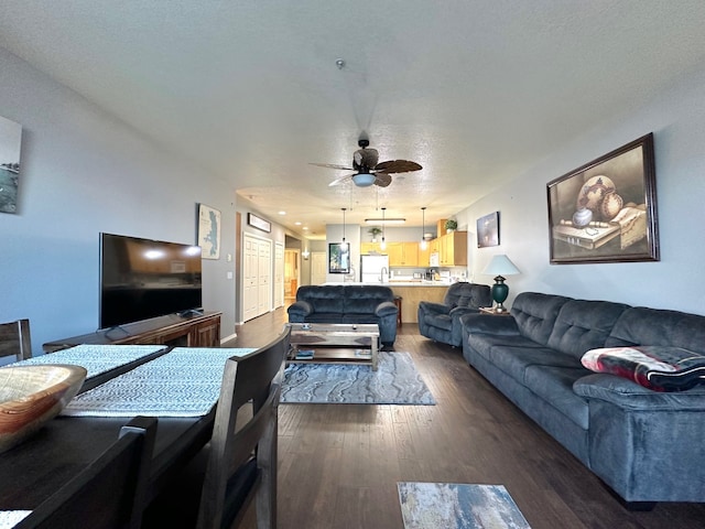 living room with dark hardwood / wood-style floors, a textured ceiling, and ceiling fan