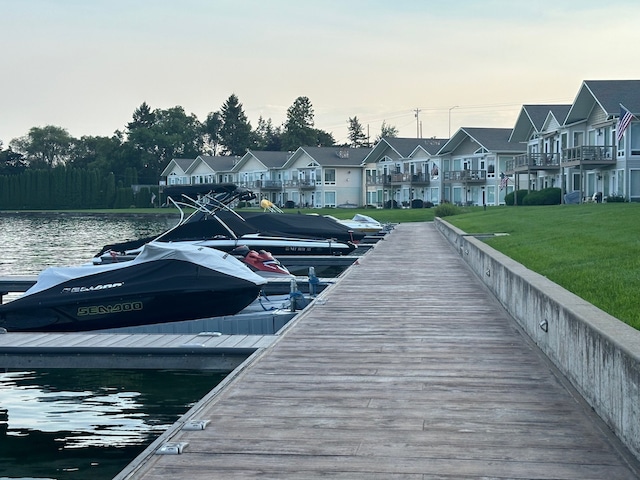 dock area featuring a water view, a yard, and a balcony