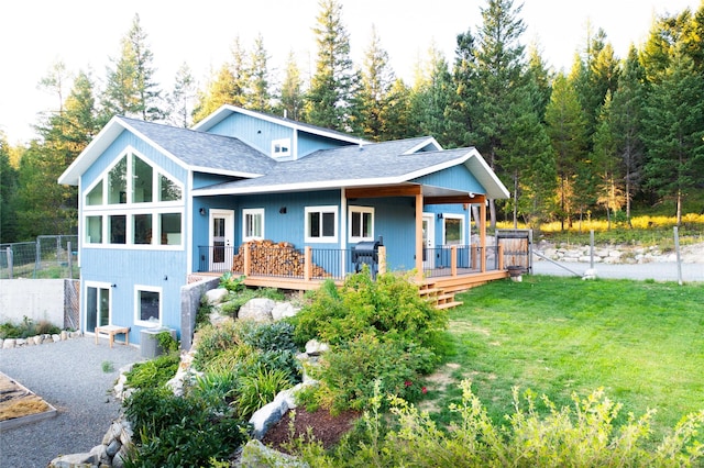 965 Ksanka Foothills Rd, Eureka, MT 59917 - rear view of house with a lawn, a wooden deck, fence, and roof with shingles