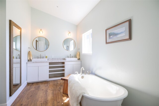 965 Ksanka Foothills Rd, Eureka, MT 59917 - full bath featuring a soaking tub, wood finished floors, two vanities, lofted ceiling, and a sink