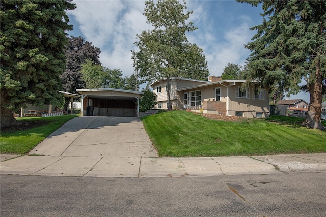 tri-level home with a carport, driveway, a chimney, and a front yard