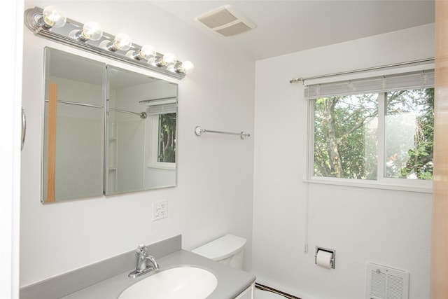 bathroom with vanity, a baseboard radiator, toilet, and visible vents