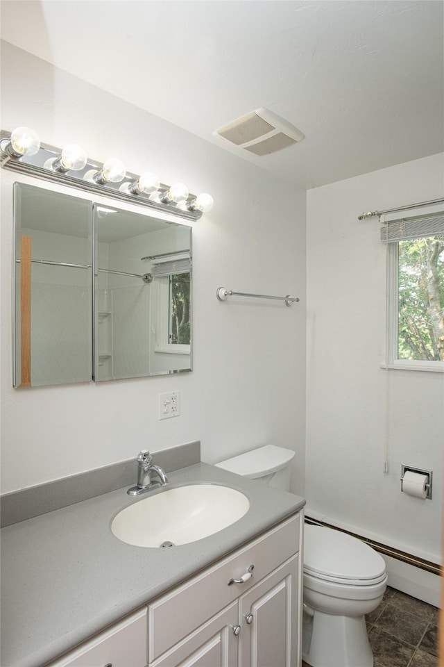 bathroom with vanity, toilet, and visible vents
