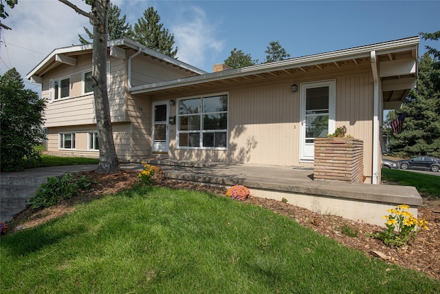 tri-level home featuring a chimney and a front yard