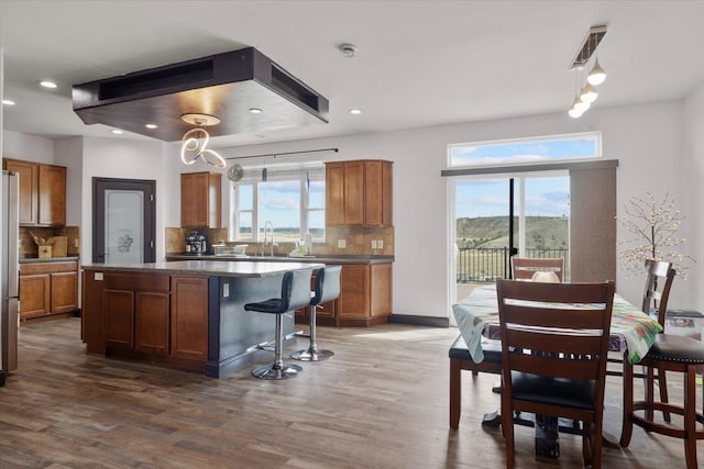 kitchen featuring backsplash, dark hardwood / wood-style floors, plenty of natural light, and a kitchen island