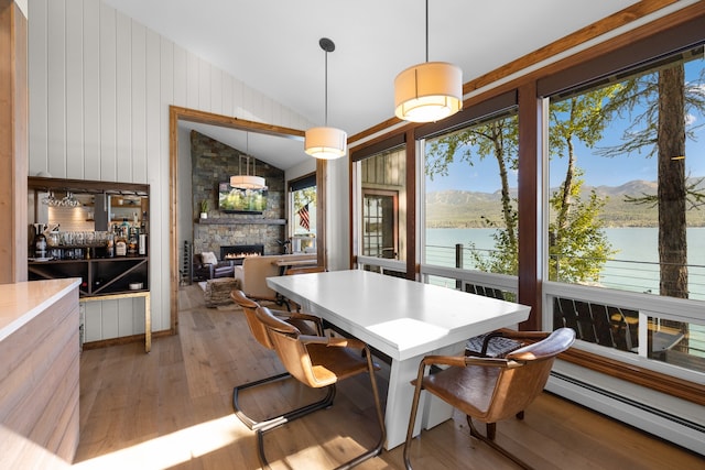 dining room featuring hardwood / wood-style floors, plenty of natural light, a water and mountain view, and baseboard heating