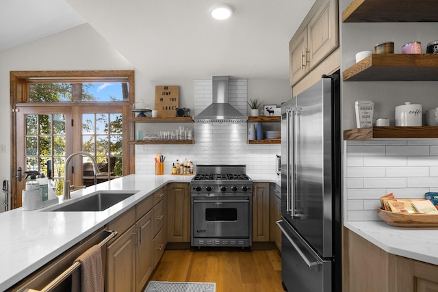 1320 W Lakeshore Dr, Whitefish, MT 59937 - kitchen with open shelves, wall chimney exhaust hood, high quality appliances, light wood-style floors, and backsplash
