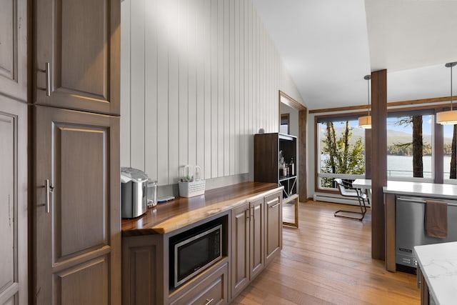 kitchen with wood counters, light wood-type flooring, appliances with stainless steel finishes, a baseboard radiator, and pendant lighting