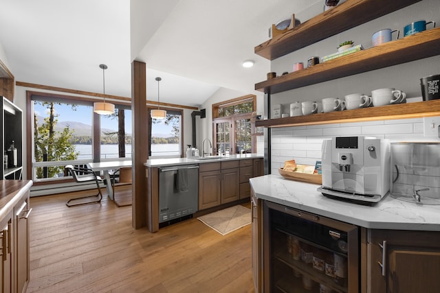 kitchen with lofted ceiling, plenty of natural light, stainless steel dishwasher, and light hardwood / wood-style floors