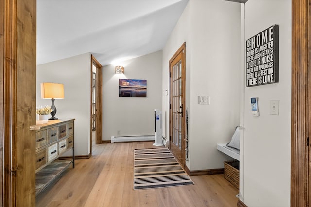 hall with vaulted ceiling, baseboard heating, and light hardwood / wood-style floors