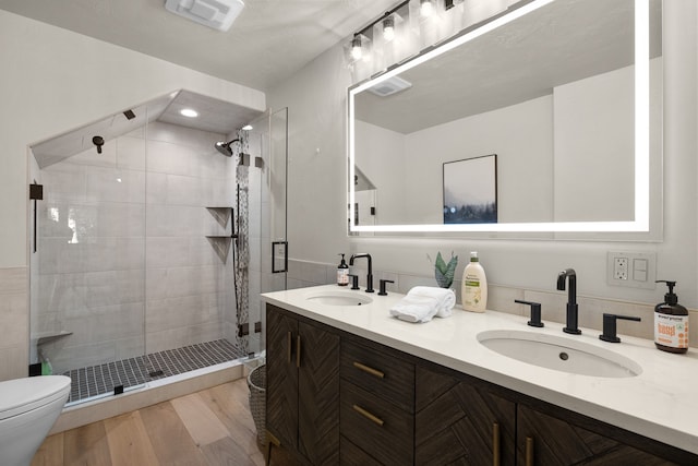 bathroom with vanity, toilet, wood-type flooring, and walk in shower