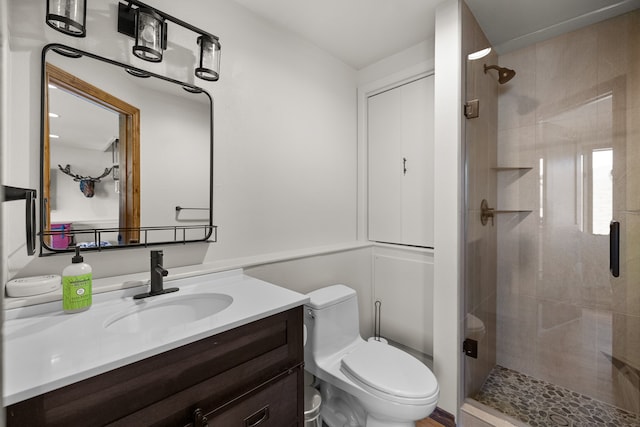 bathroom featuring vanity, toilet, and a shower with shower door