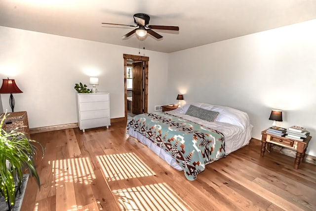 bedroom with ceiling fan, connected bathroom, and light hardwood / wood-style floors