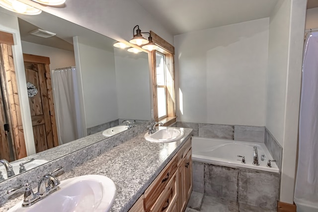 bathroom with vanity and tiled tub