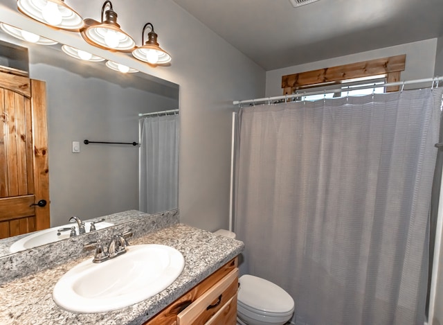 bathroom with vanity, toilet, and walk in shower