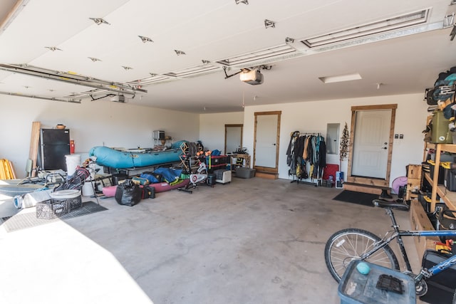 garage featuring a garage door opener and black fridge