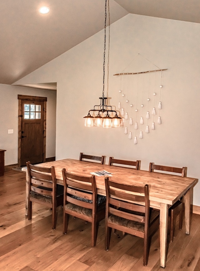 dining space with vaulted ceiling and hardwood / wood-style flooring