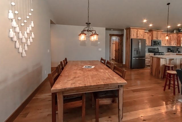 dining room with light hardwood / wood-style flooring and a chandelier