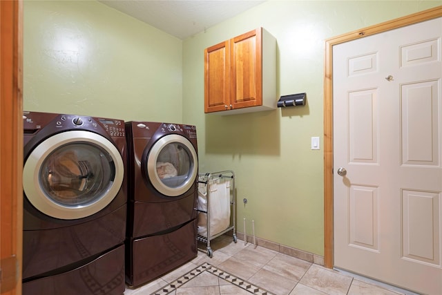 laundry area featuring cabinet space, independent washer and dryer, baseboards, and light tile patterned floors