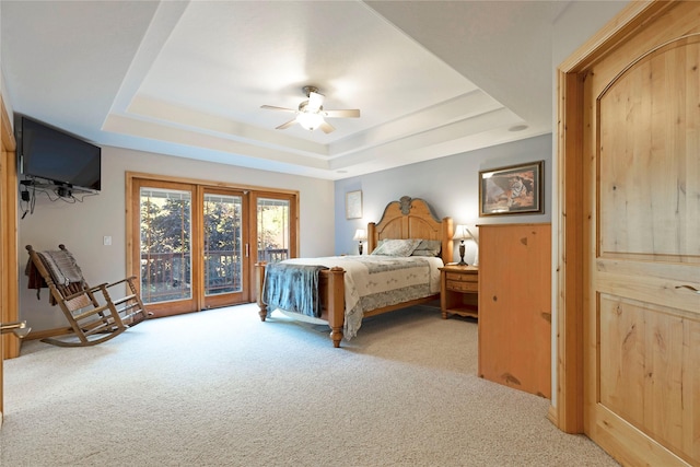 carpeted bedroom featuring ceiling fan, access to outside, and a raised ceiling