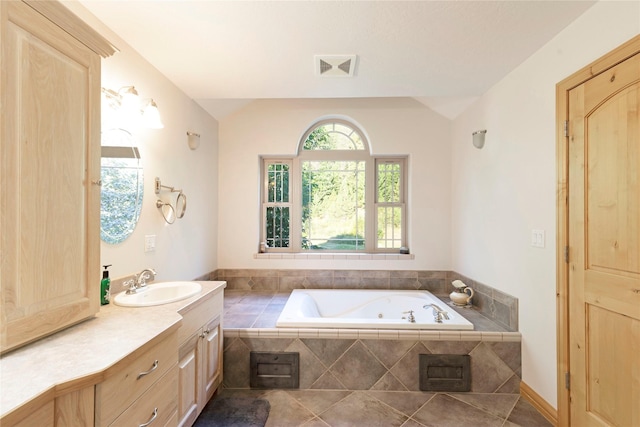 bathroom with visible vents, tile patterned floors, vaulted ceiling, vanity, and a bath