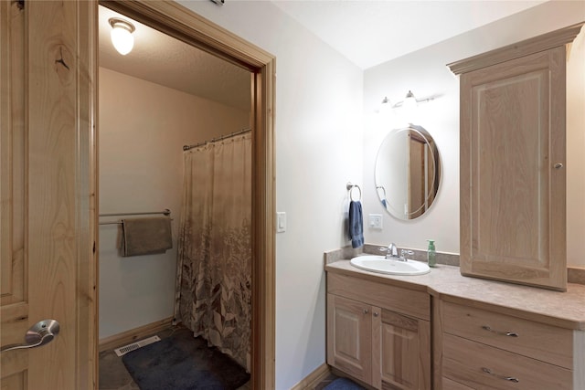 bathroom with curtained shower, baseboards, visible vents, and vanity