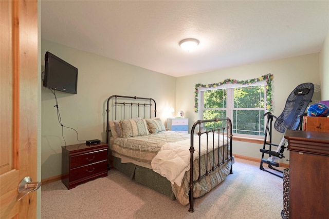 bedroom with light colored carpet and baseboards