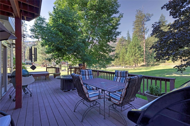 deck with outdoor dining area and a lawn