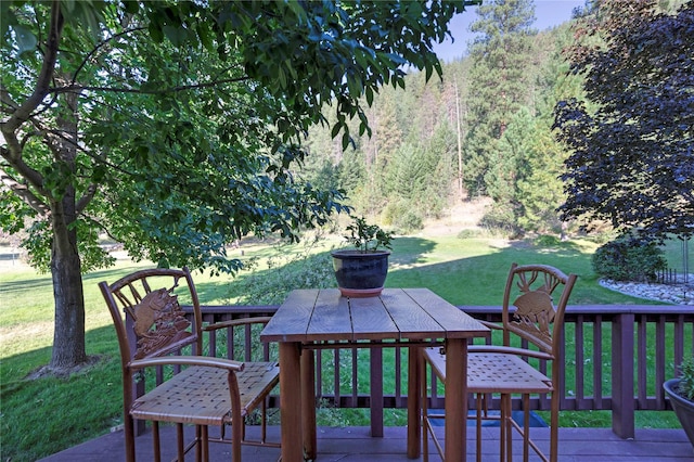 deck with a forest view and a yard