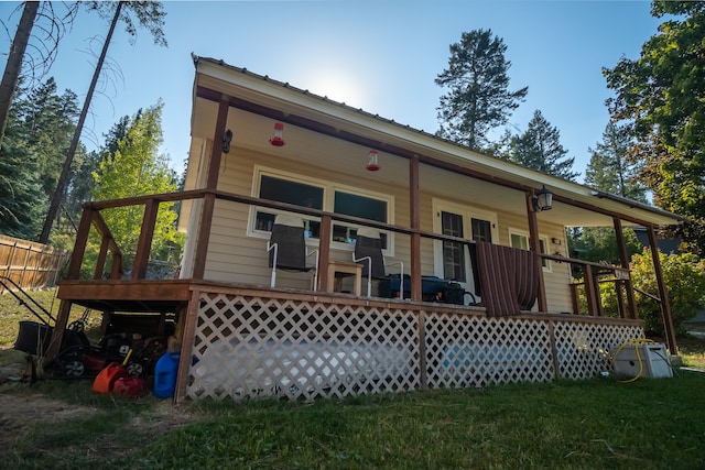 back of property with a wooden deck and a yard