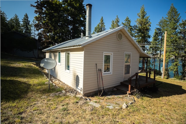 view of property exterior featuring a yard and a wooden deck