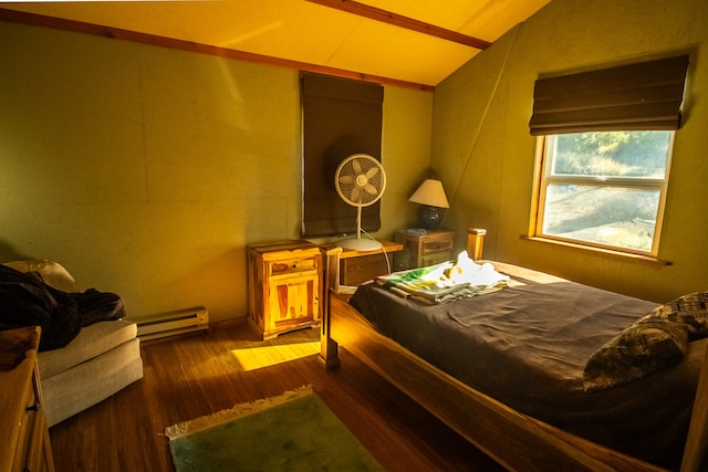 bedroom with a baseboard heating unit, dark hardwood / wood-style flooring, and lofted ceiling