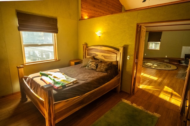 bedroom with lofted ceiling and wood-type flooring