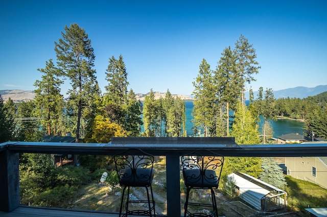 balcony featuring a water and mountain view