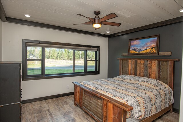 bedroom featuring ceiling fan, light hardwood / wood-style floors, and wood ceiling