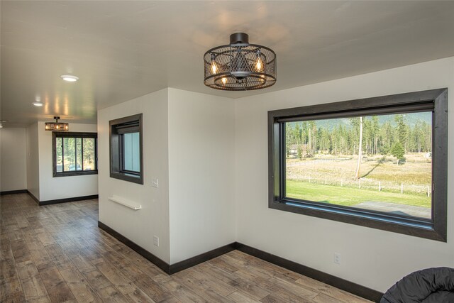 interior space with plenty of natural light, hardwood / wood-style floors, and an inviting chandelier