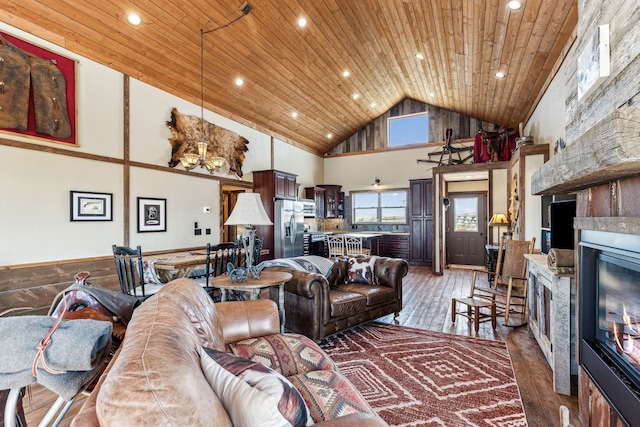 living room featuring hardwood / wood-style floors, wooden ceiling, a fireplace, and high vaulted ceiling