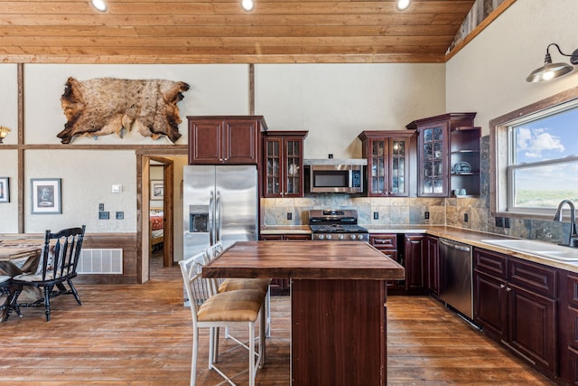 kitchen featuring lofted ceiling, wooden ceiling, wooden counters, sink, and appliances with stainless steel finishes