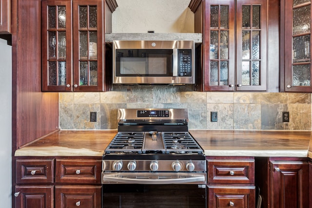 kitchen with appliances with stainless steel finishes and backsplash