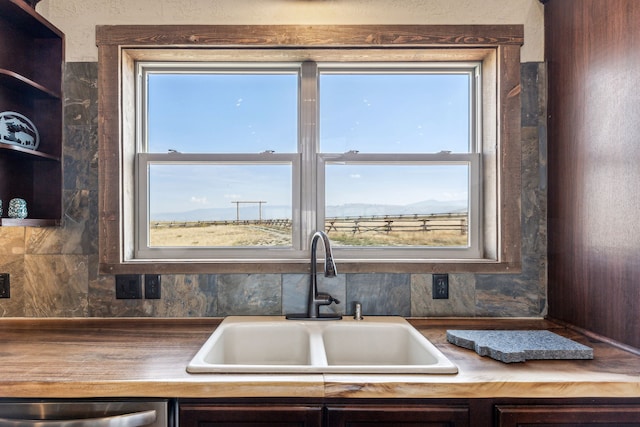 kitchen featuring dishwasher, dark brown cabinets, and sink