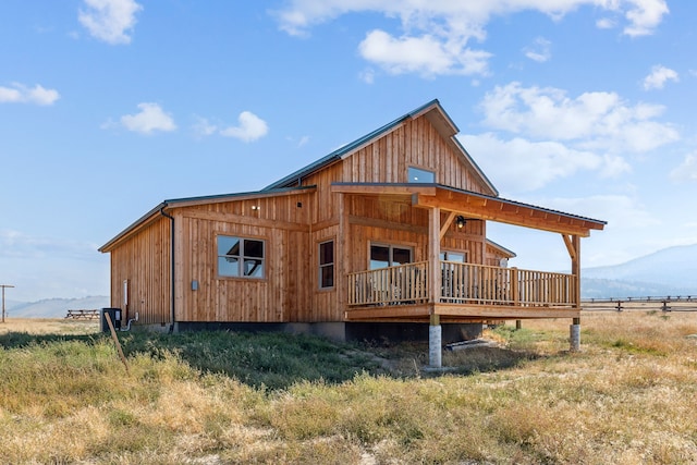 rear view of house featuring a rural view and a deck