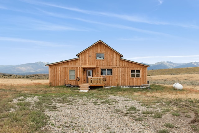 back of property with a mountain view and a rural view