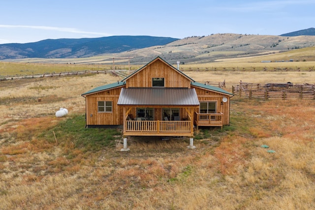 view of front facade with a deck with mountain view and a rural view